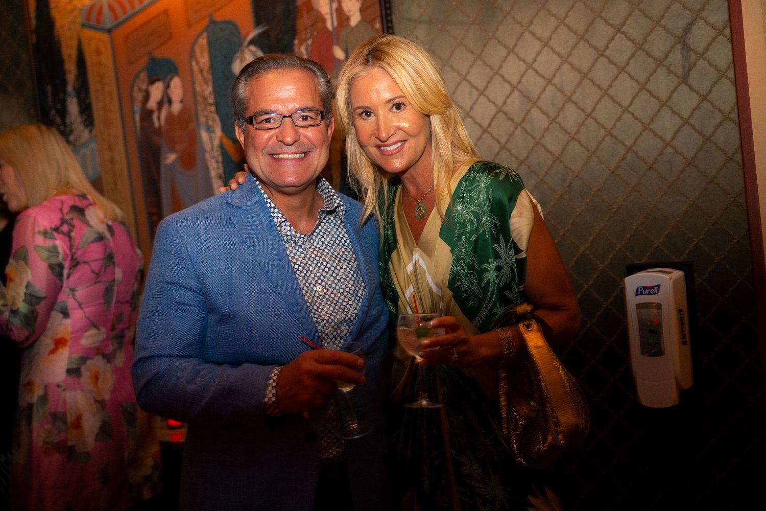 Guests mingling at an upscale venue with orange-lit walls and elegant decor.