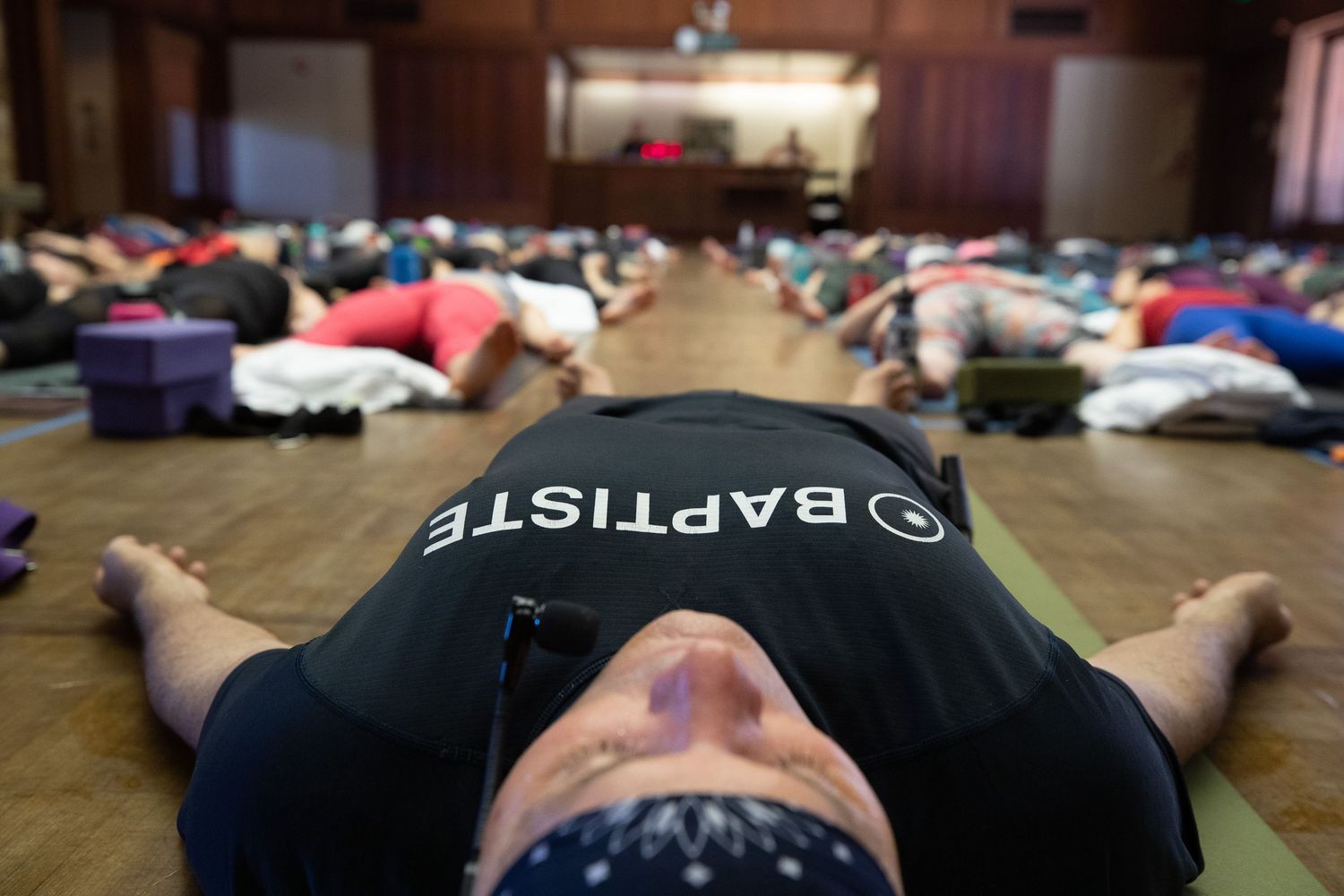 People lay on yoga mats during a wellness activity in a communal space.