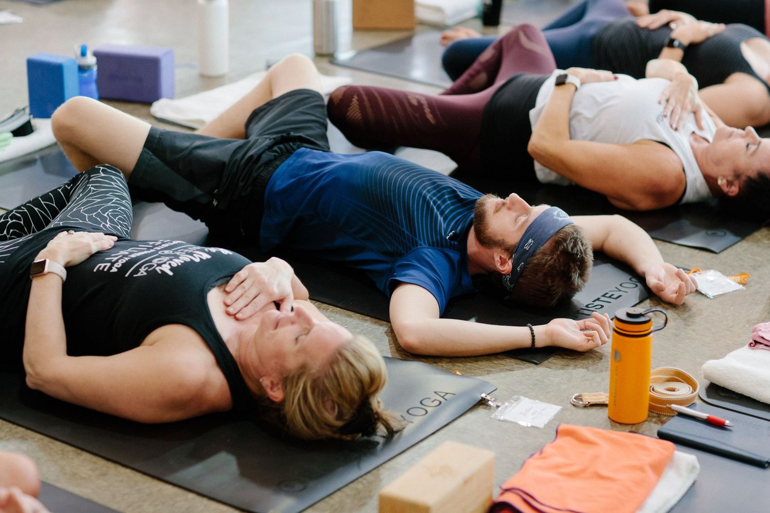 Group resting on exercise mats during a fitness class cool-down session.
