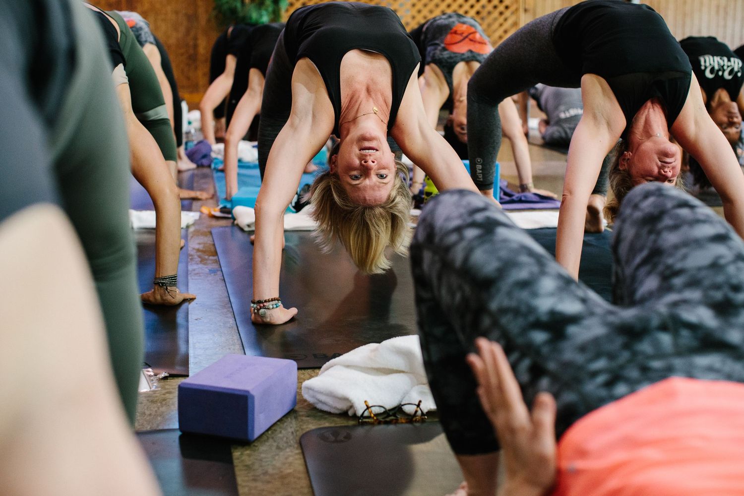 Yoga practitioners in downward dog pose during a group fitness class.
