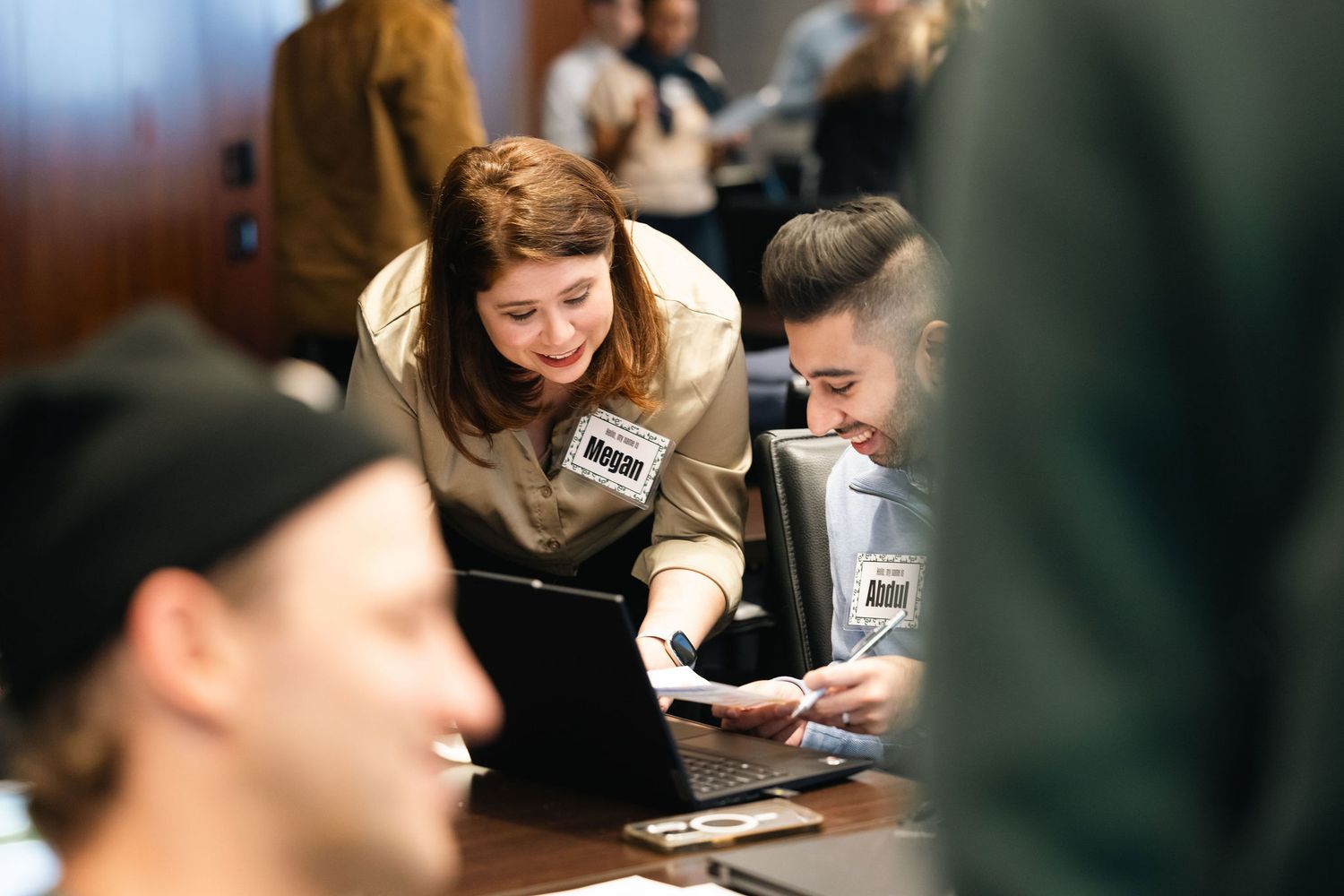 NY Photographer shoots a group of people working together at a table with laptops and papers during a collaborative business event.
