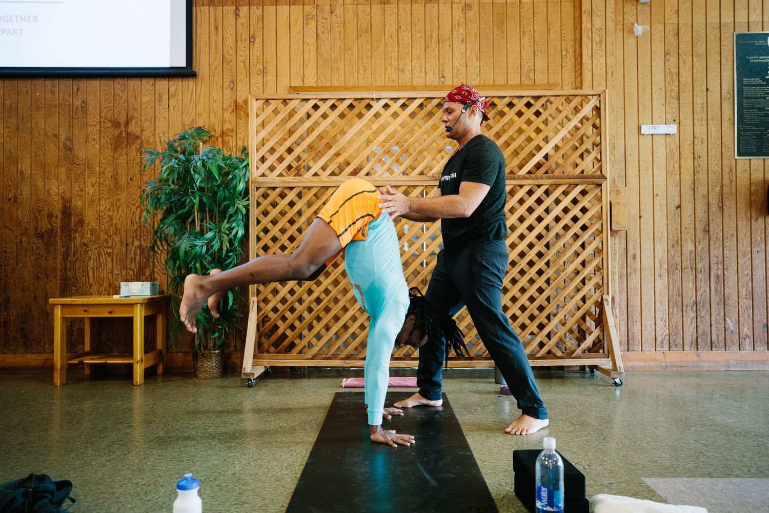 Dance partners practicing choreography in a rustic wooden studio space during rehearsal.