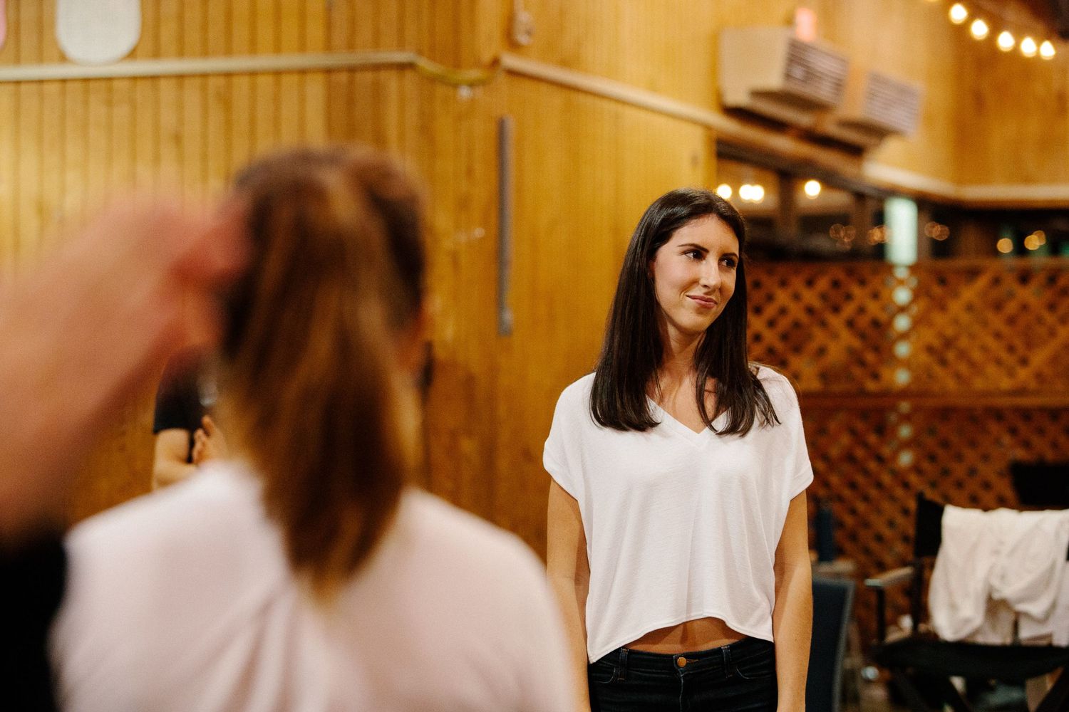 A conversation takes place in a rustic wooden venue decorated with string lights and lattice details.