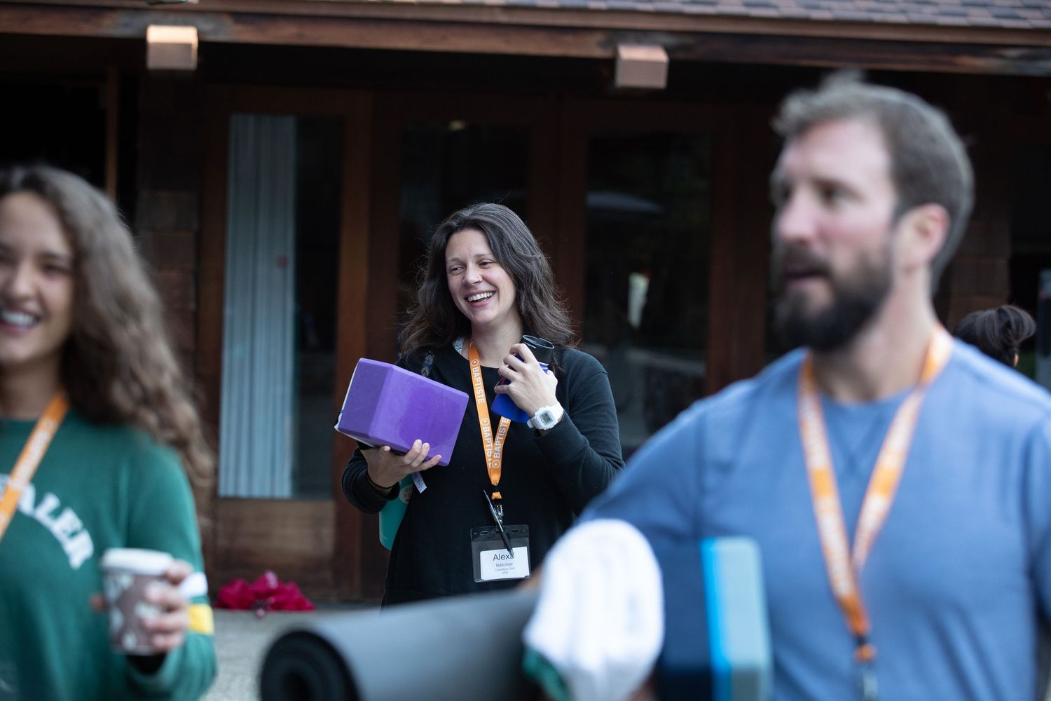 Conference attendees engage in casual networking discussions in a hallway.