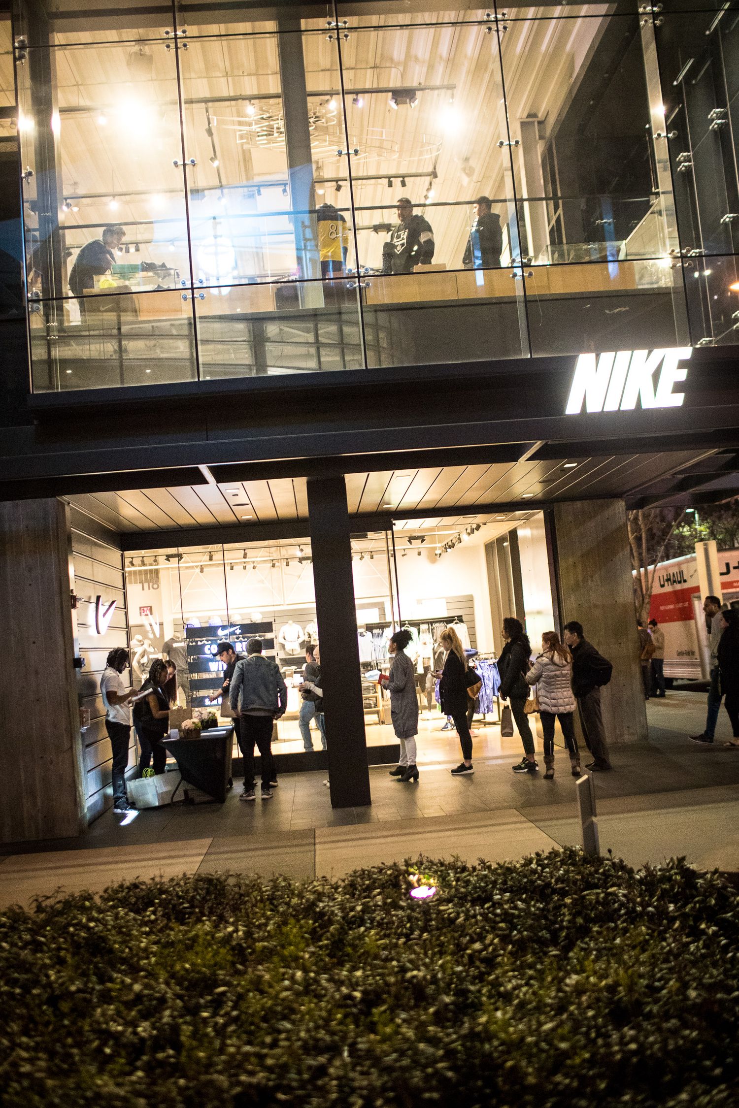 Modern retail space with illuminated Nike signage and glass displays at night.