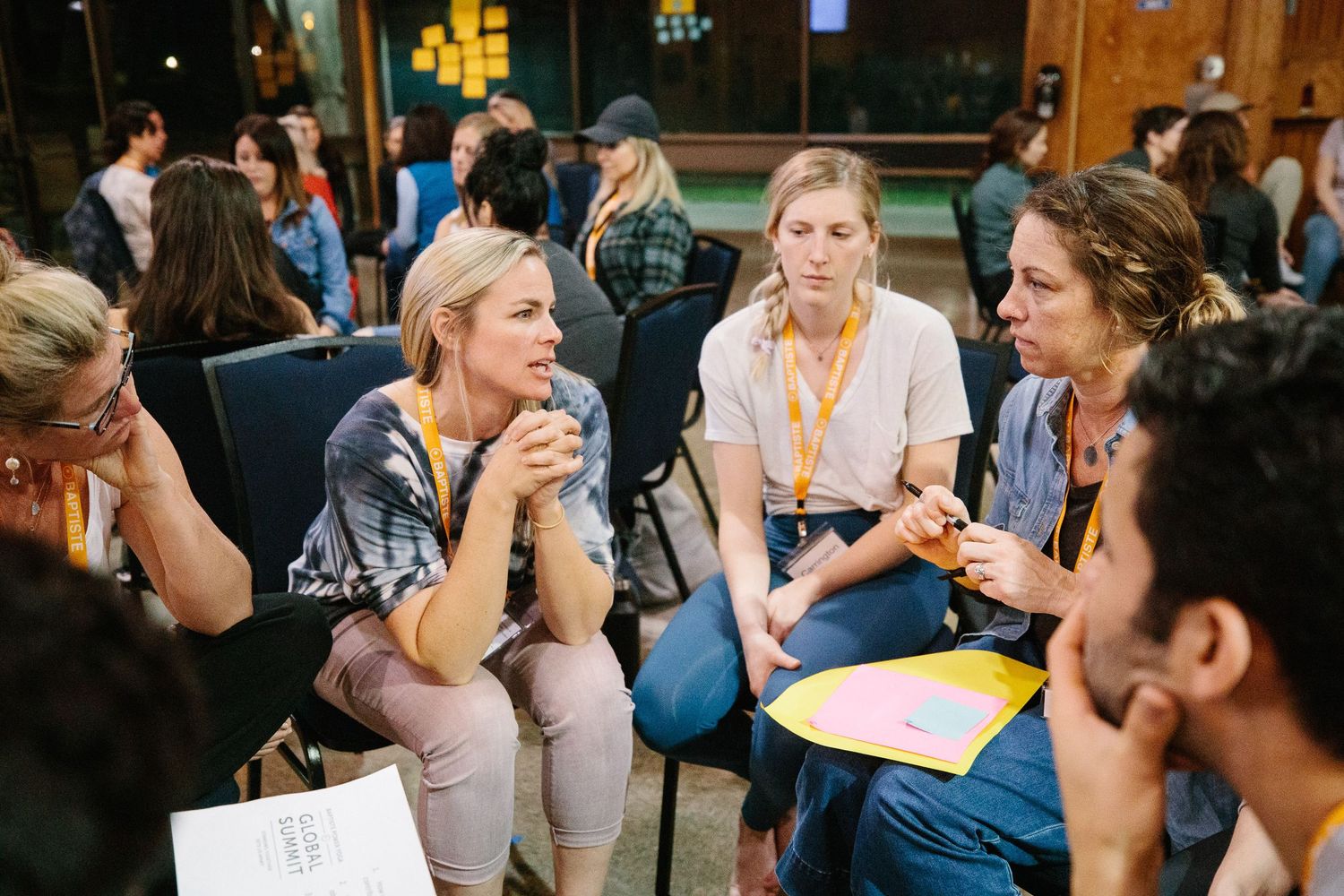 Workshop participants engaged in small group discussions while seated on the floor.