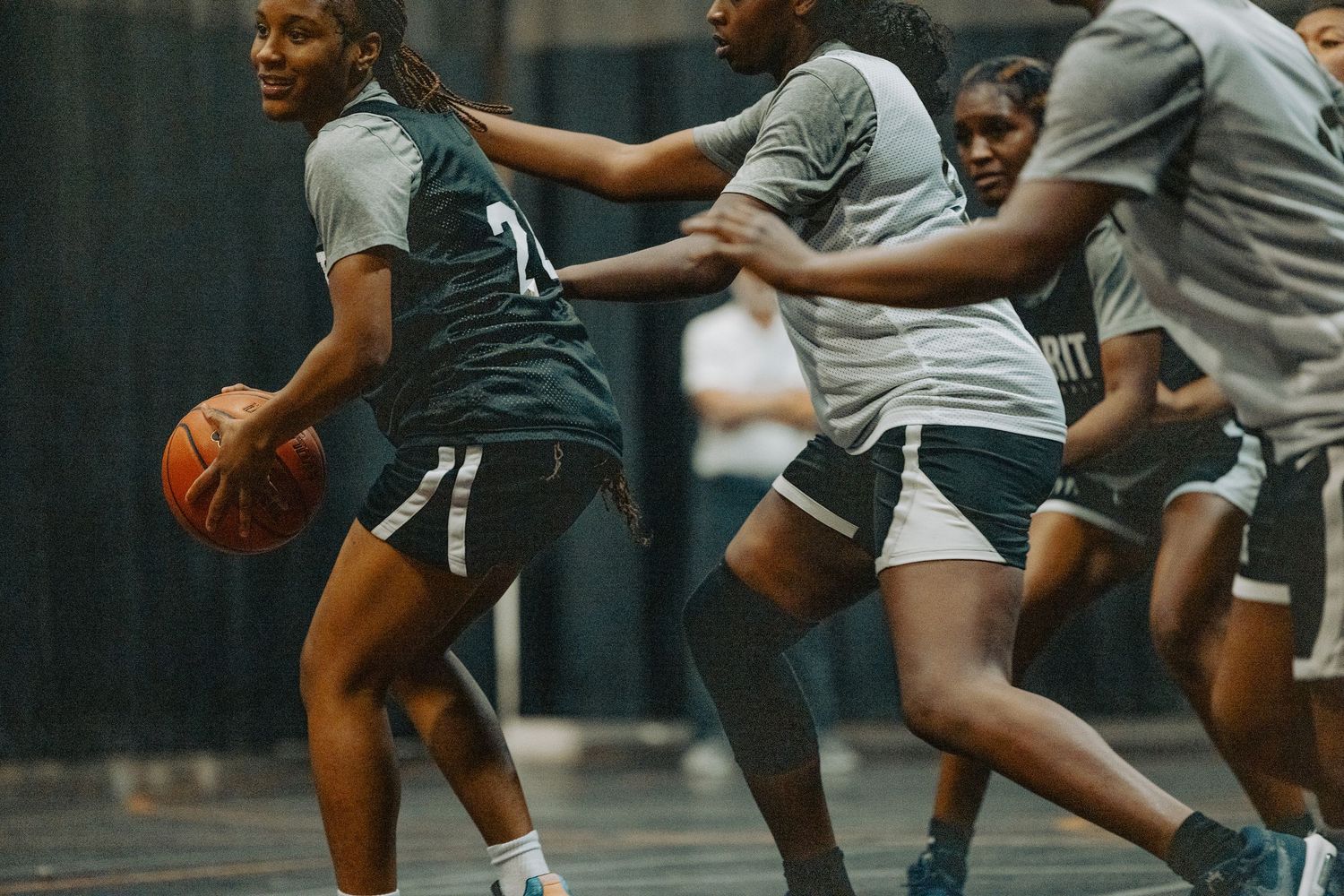 Players compete for possession during an intense basketball practice session.