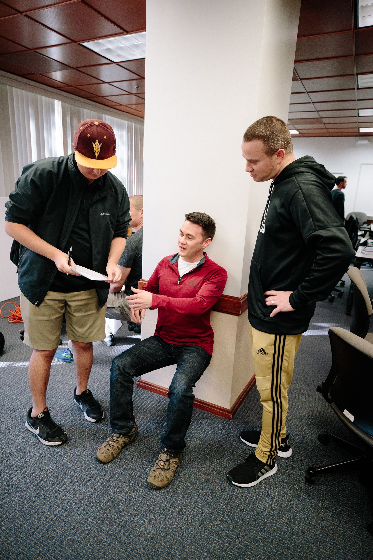 Three people having a casual meeting discussion in an office setting.