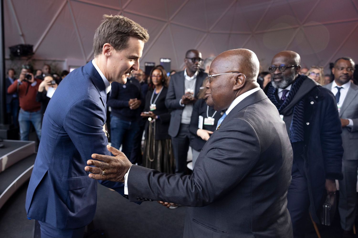 Formal gathering with people in suits interacting at an evening event.