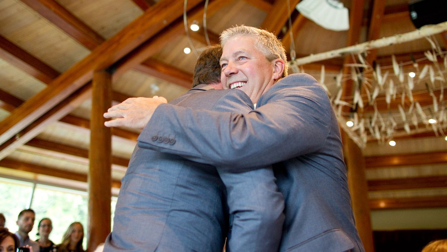 Two people sharing a warm embrace at what appears to be a wedding reception.
