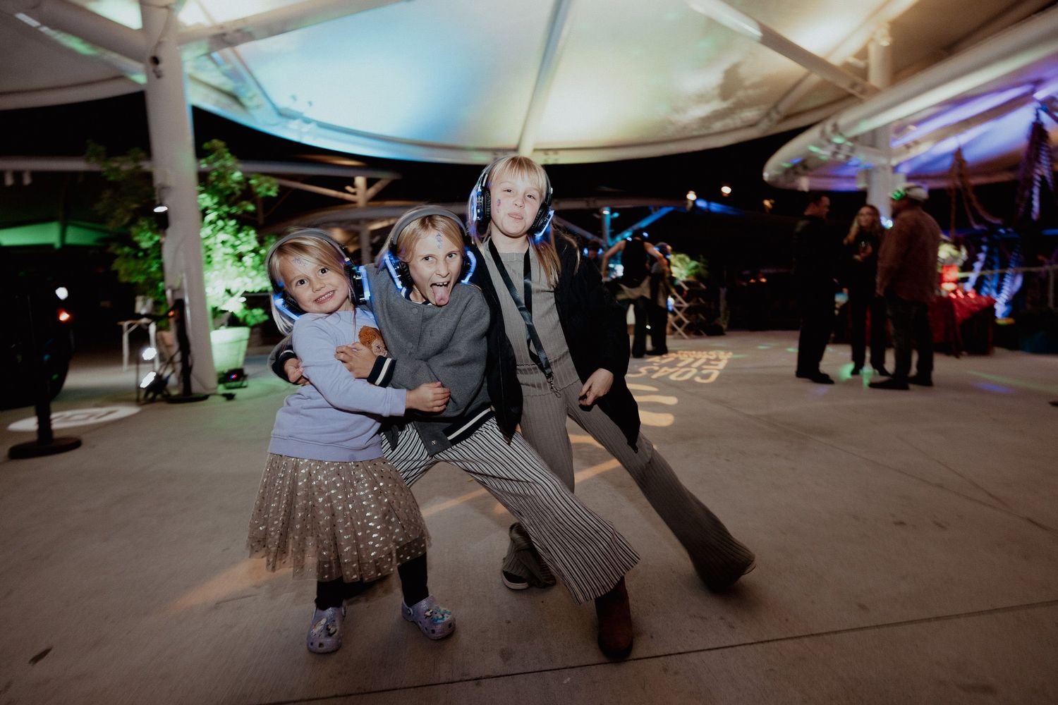 People dancing and moving on an illuminated outdoor dance floor.