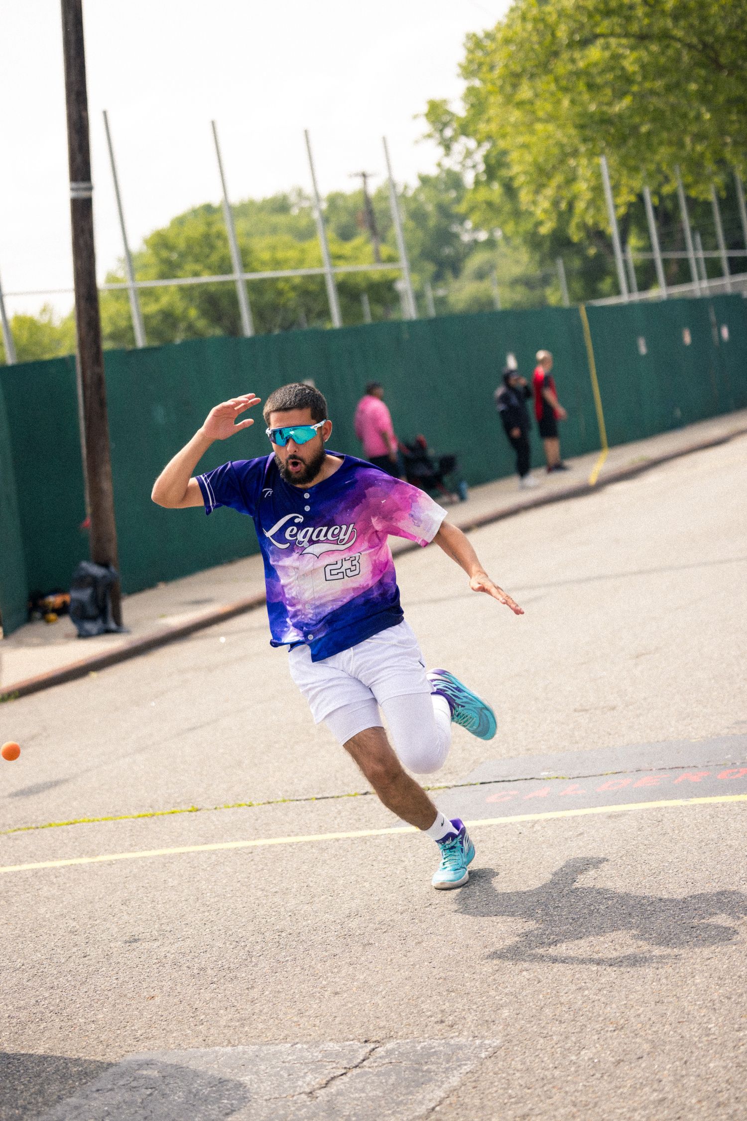 Person in athletic wear performs advanced sliding dance moves on a concrete surface.