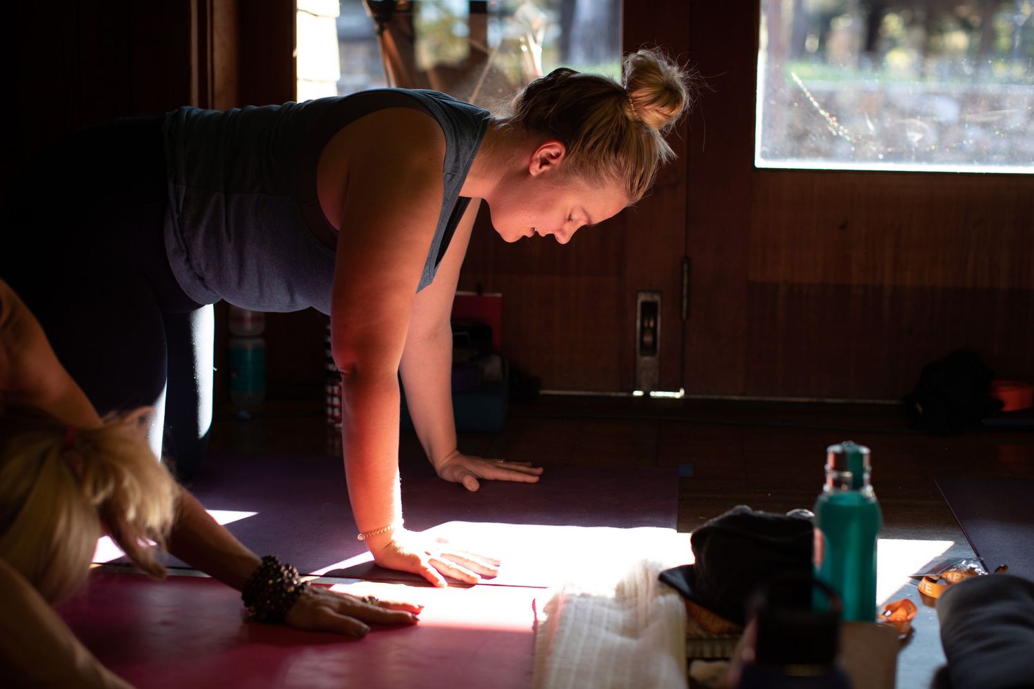 Sunlight streams through windows as participants engage in floor exercises.