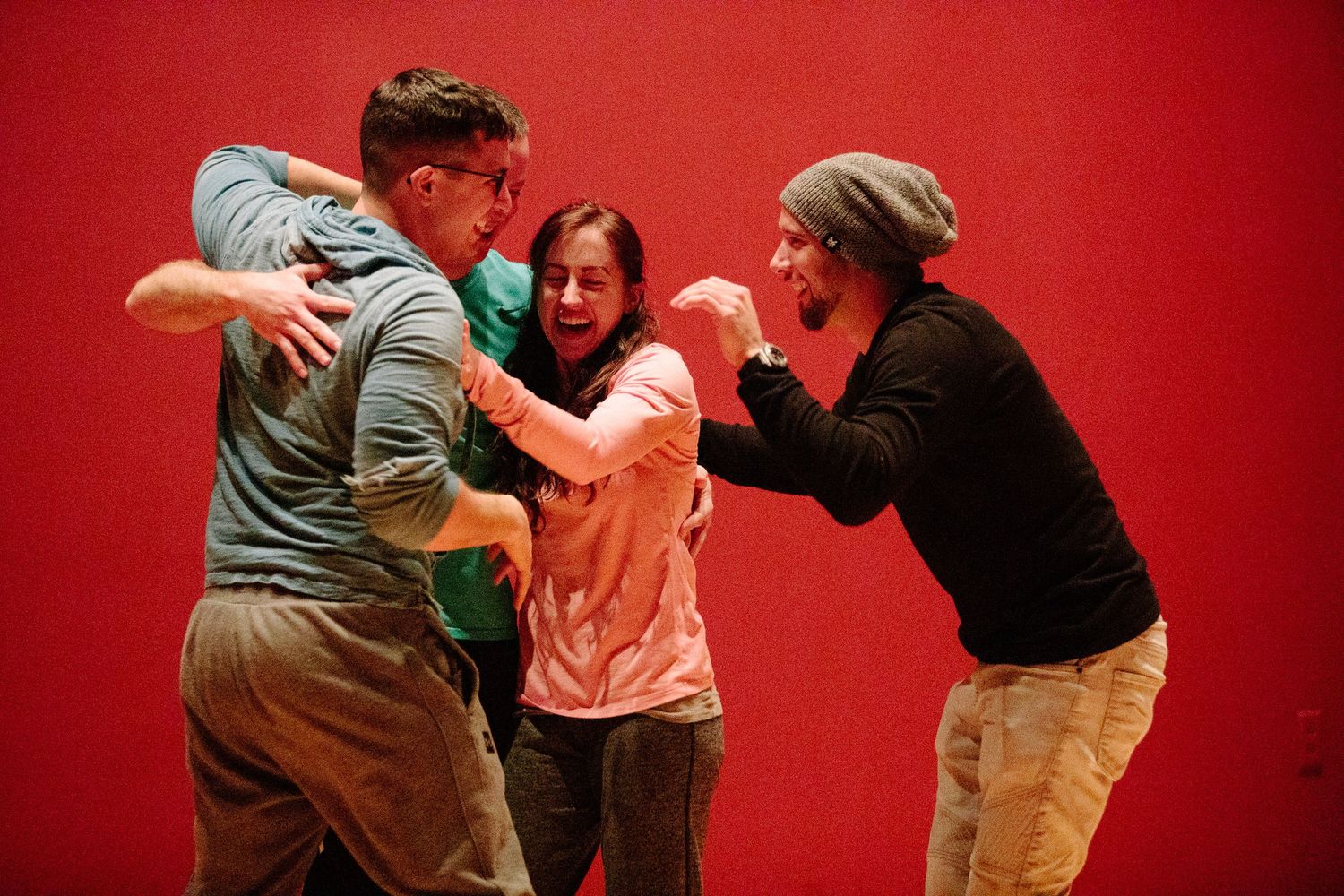 Group movement exercise in a studio with red walls showing dynamic interaction between participants.