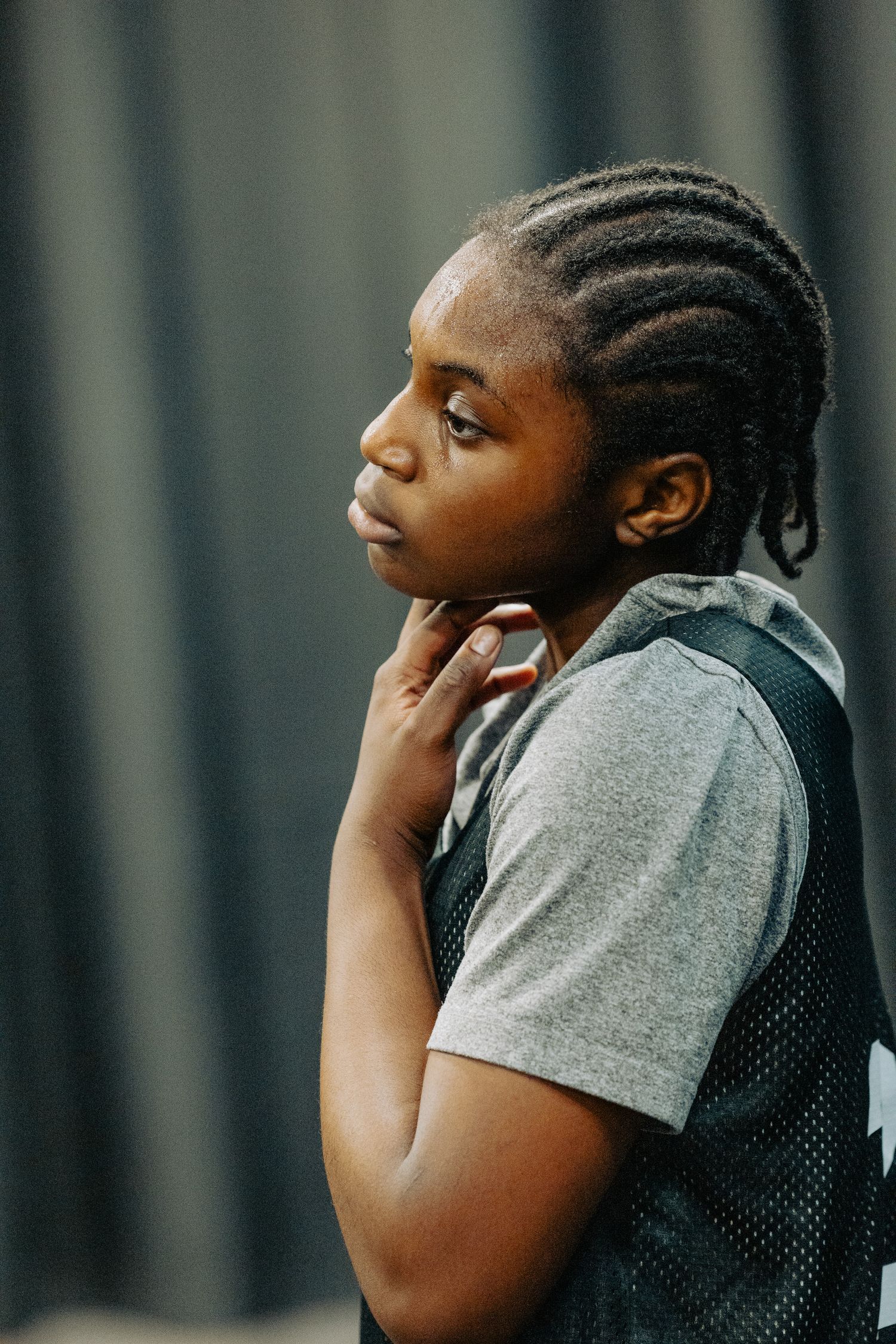 Basketball player in grey jersey shows focused concentration during practice session.