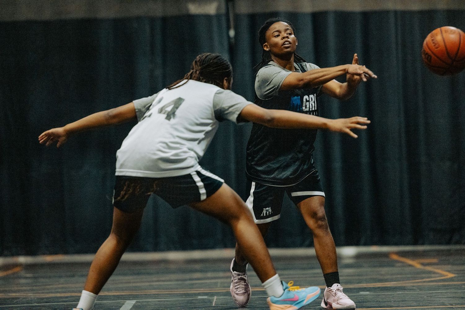 Basketball players dive and stretch across the court attempting to gain control of a loose ball during an intense game.