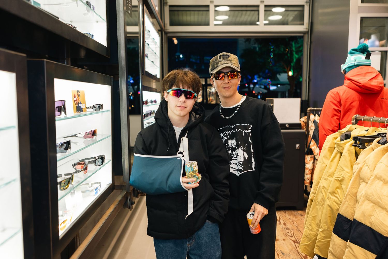Two people standing in front of a retail display wearing casual clothes and accessories.