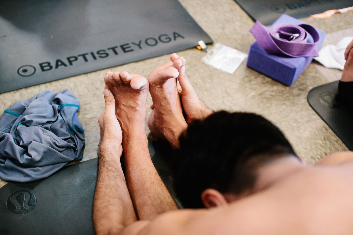 Close-up of hands and yoga mats during a Baptiste yoga session.