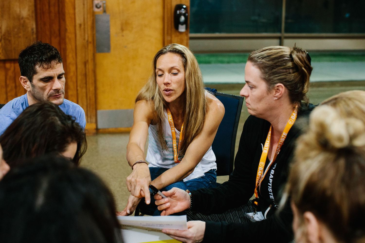 People gathered in discussion around tables during a wellness workshop.