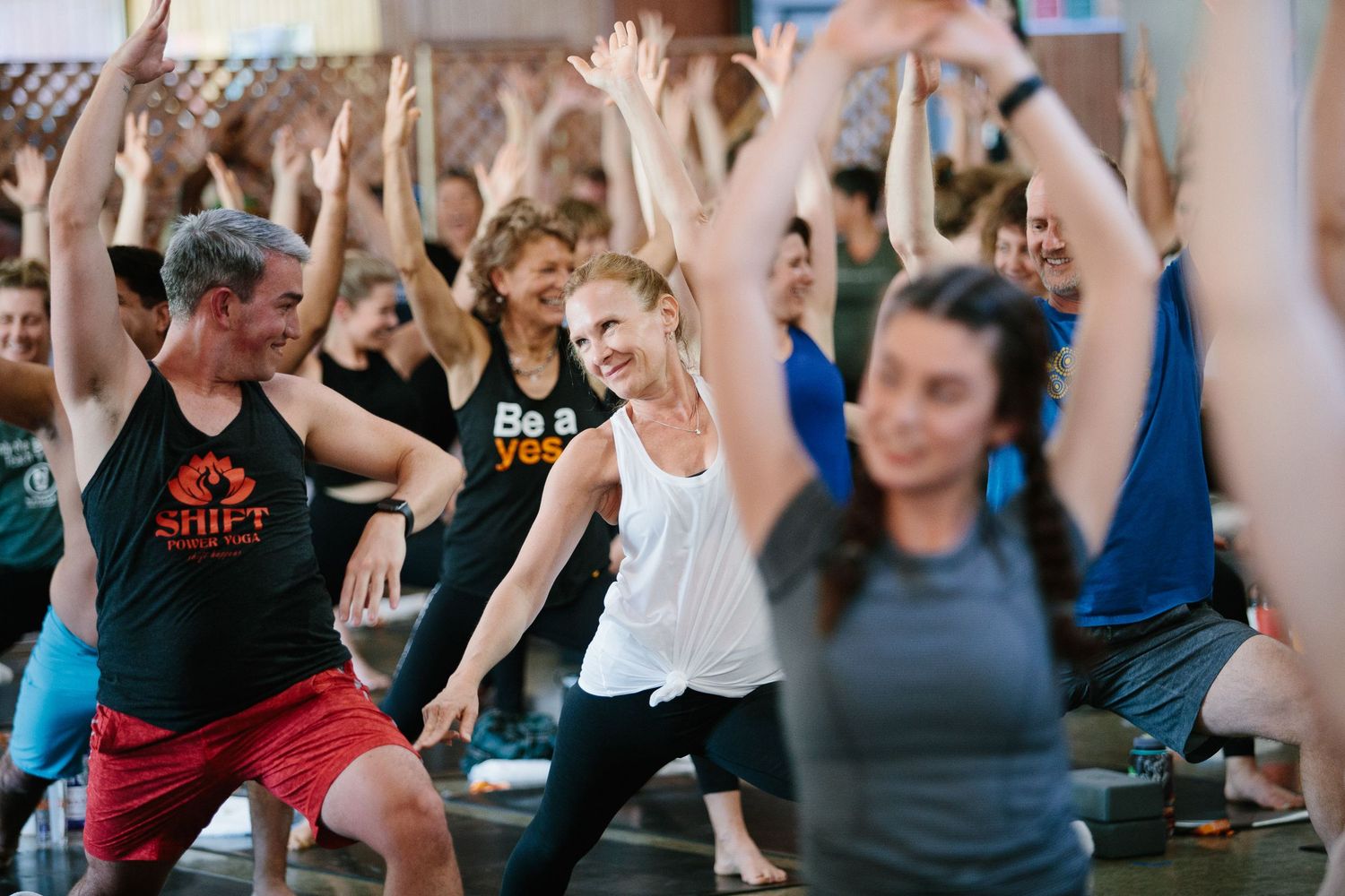 Enthusiastic group raising hands during an energetic fitness workshop.