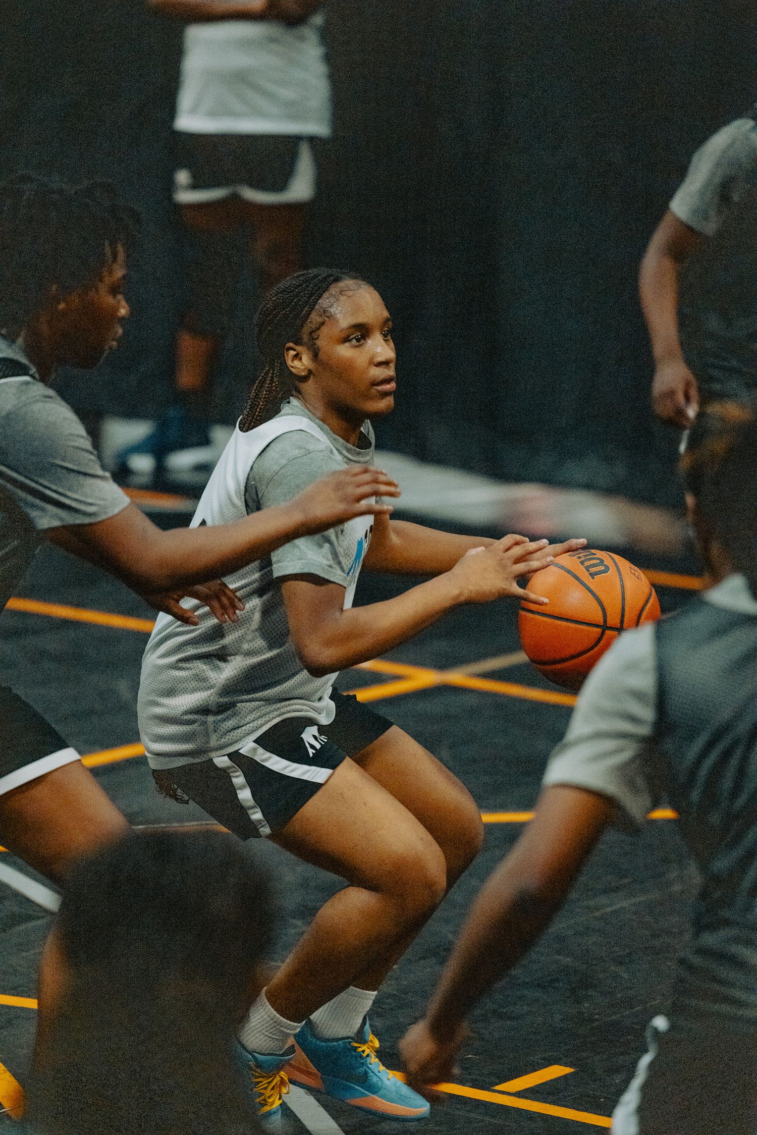 Basketball player drives through defense during indoor game practice.