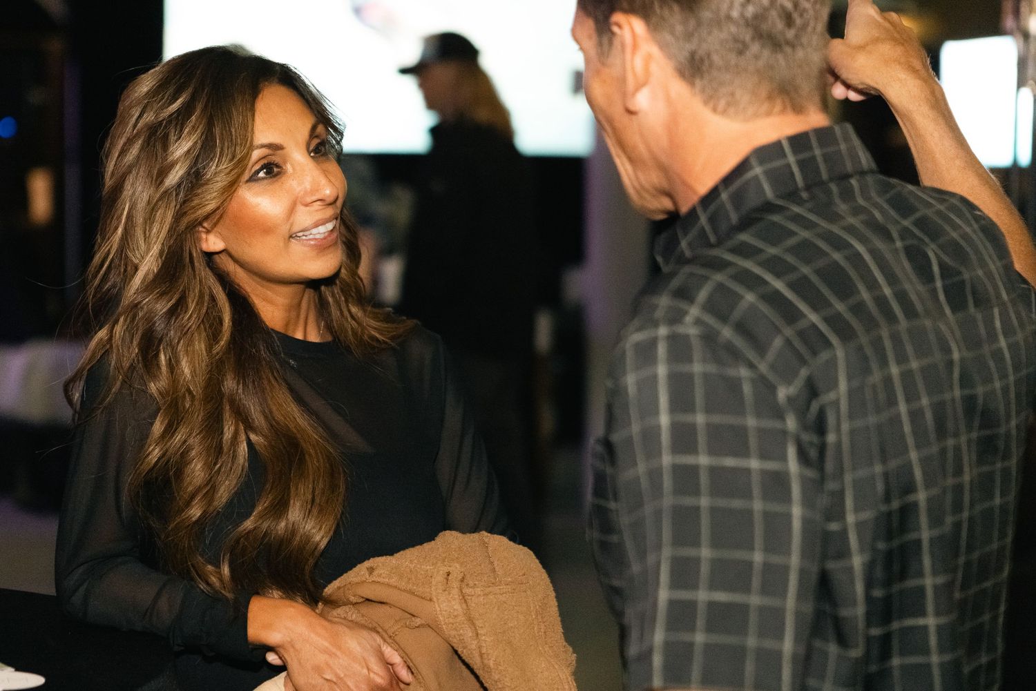 Attendees at an evening social event interacting and having conversations in casual attire.