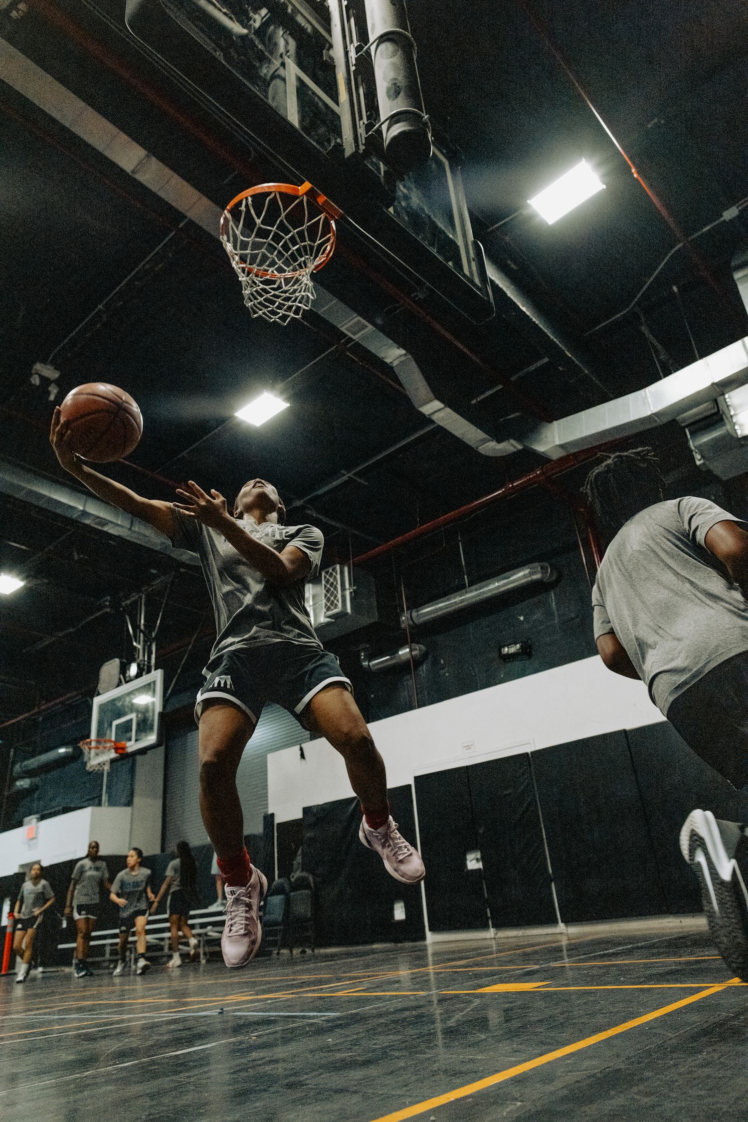 Player leaps high for a layup shot at the basketball hoop during practice.