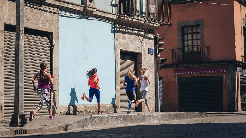 Urban street scene with brick buildings and pedestrians walking in bright daylight.