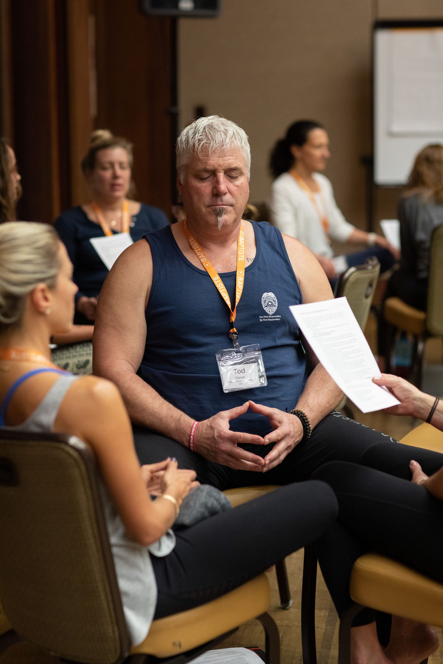 A group participates in a seated workshop or training session in a conference room setting.