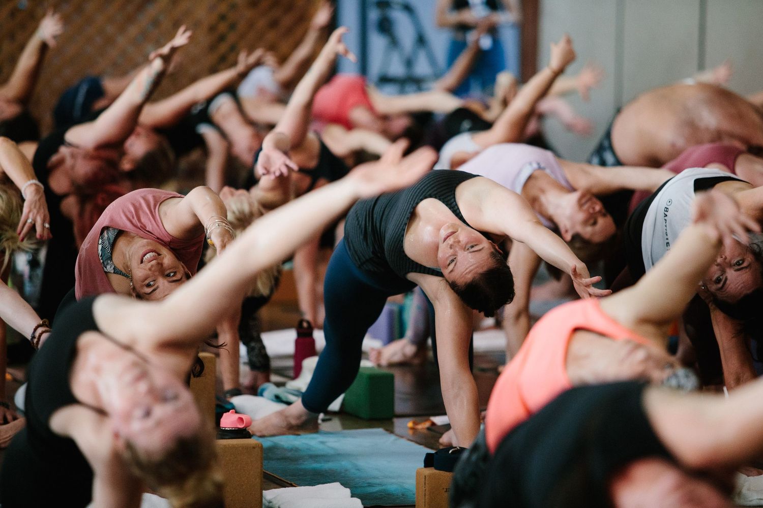 Group exercise participants stretching with arms raised during a fitness class.