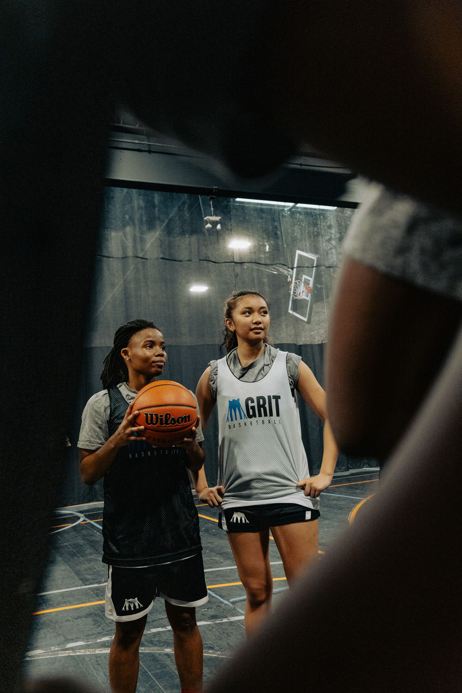 Basketball players practicing drills and techniques in an indoor gym setting.
