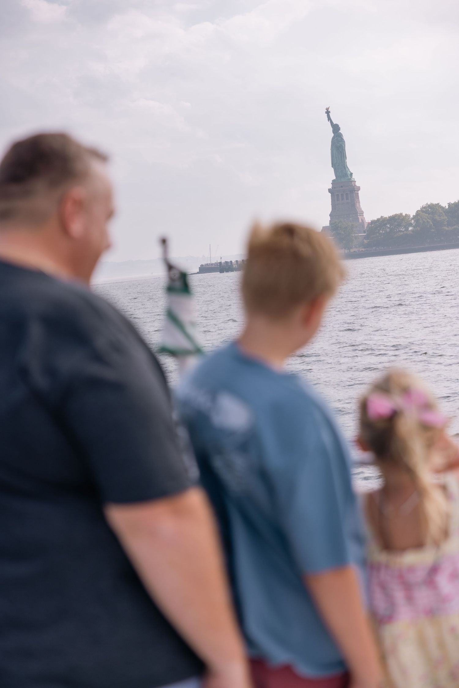People viewing the Statue of Liberty from a boat on a misty day.