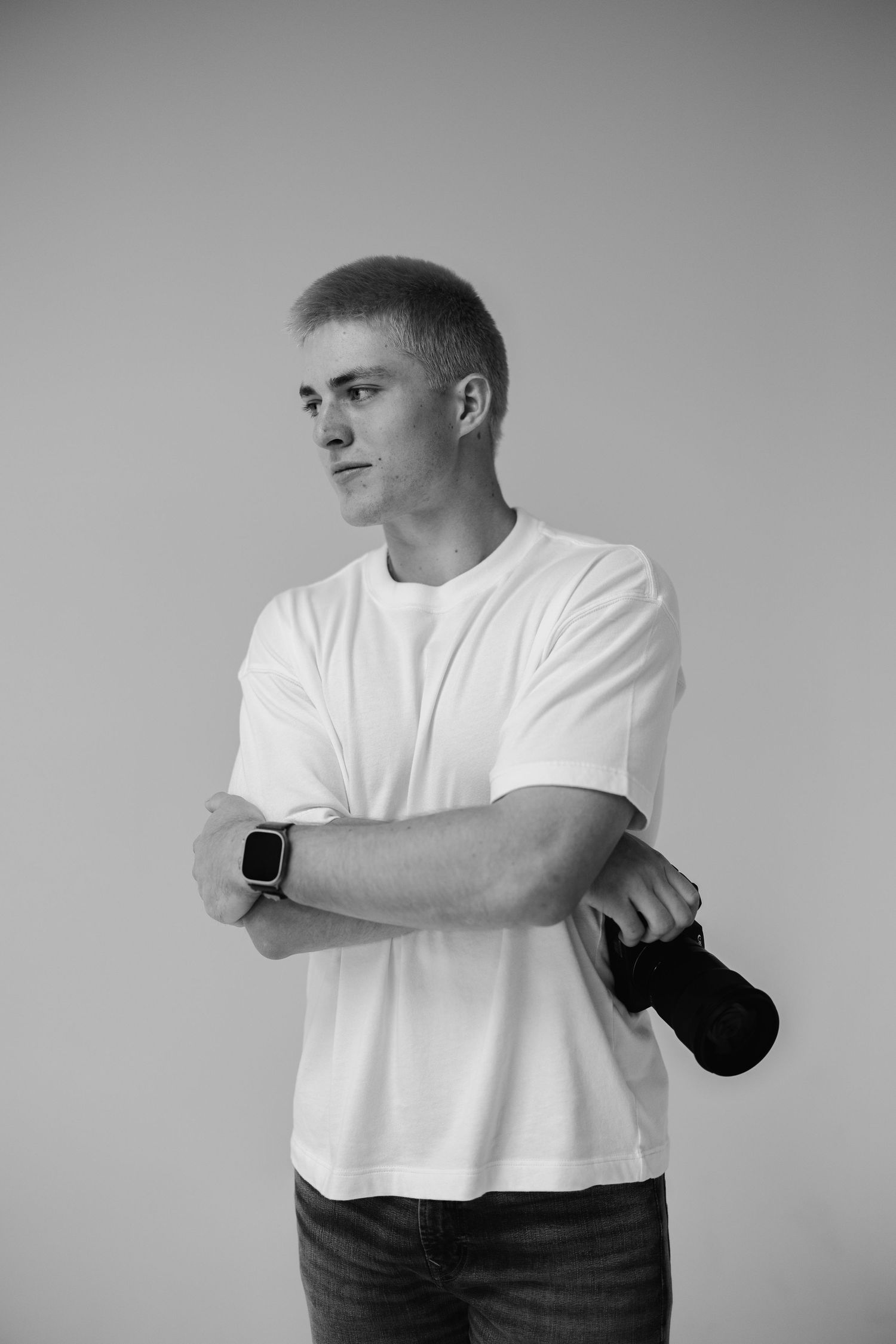 Black and white portrait of person in casual wear against grey backdrop.