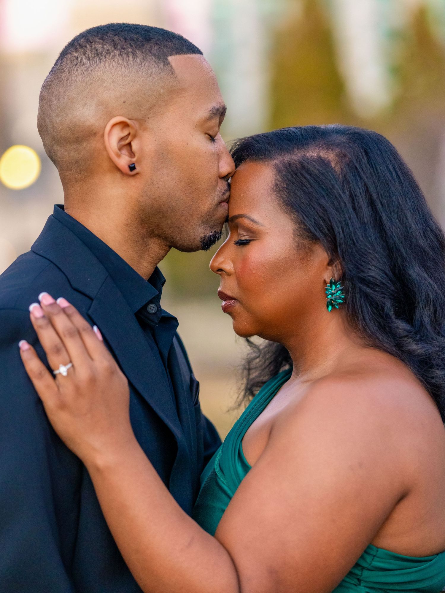 A romantic couple shares an intimate moment while dressed in formal evening wear.