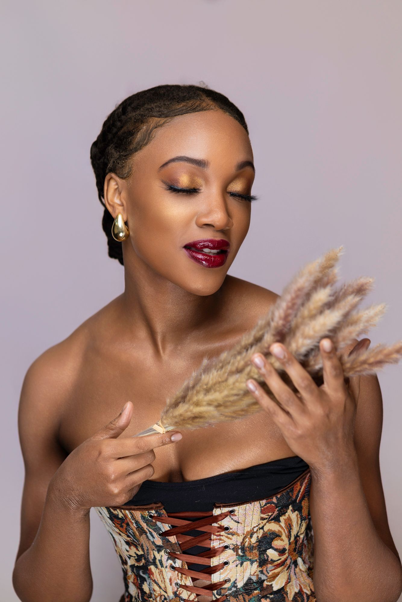 Artistic portrait with dried pampas grass and strapless floral dress.
