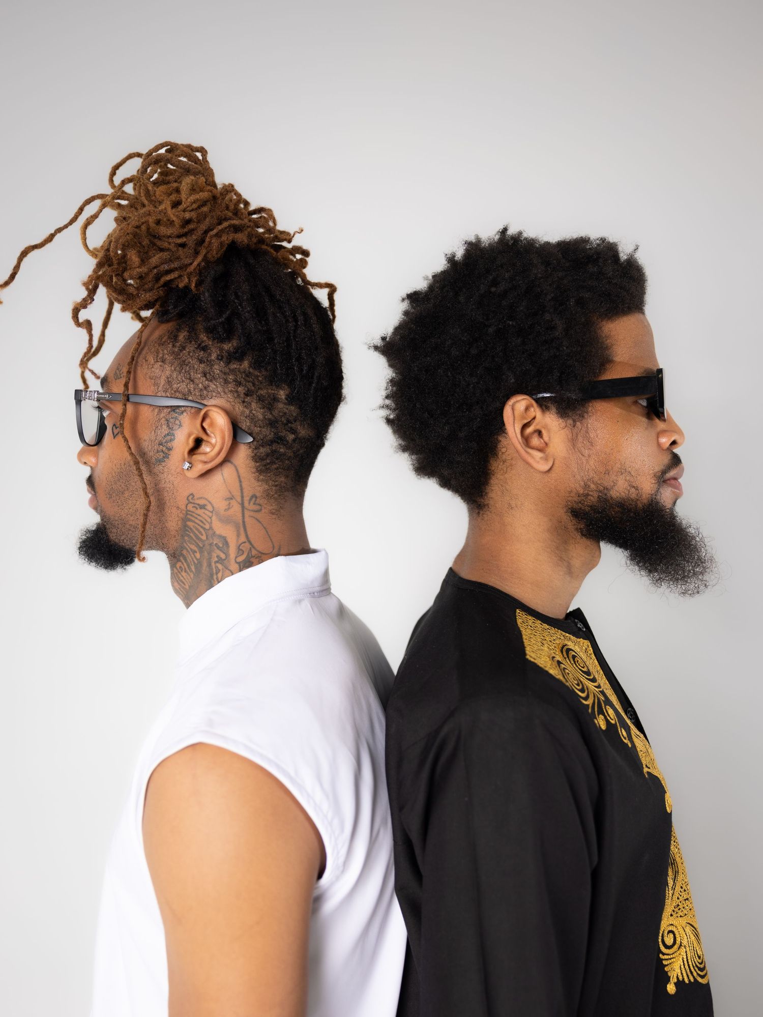 Two models in contrasting black and white outfits pose together against white background.