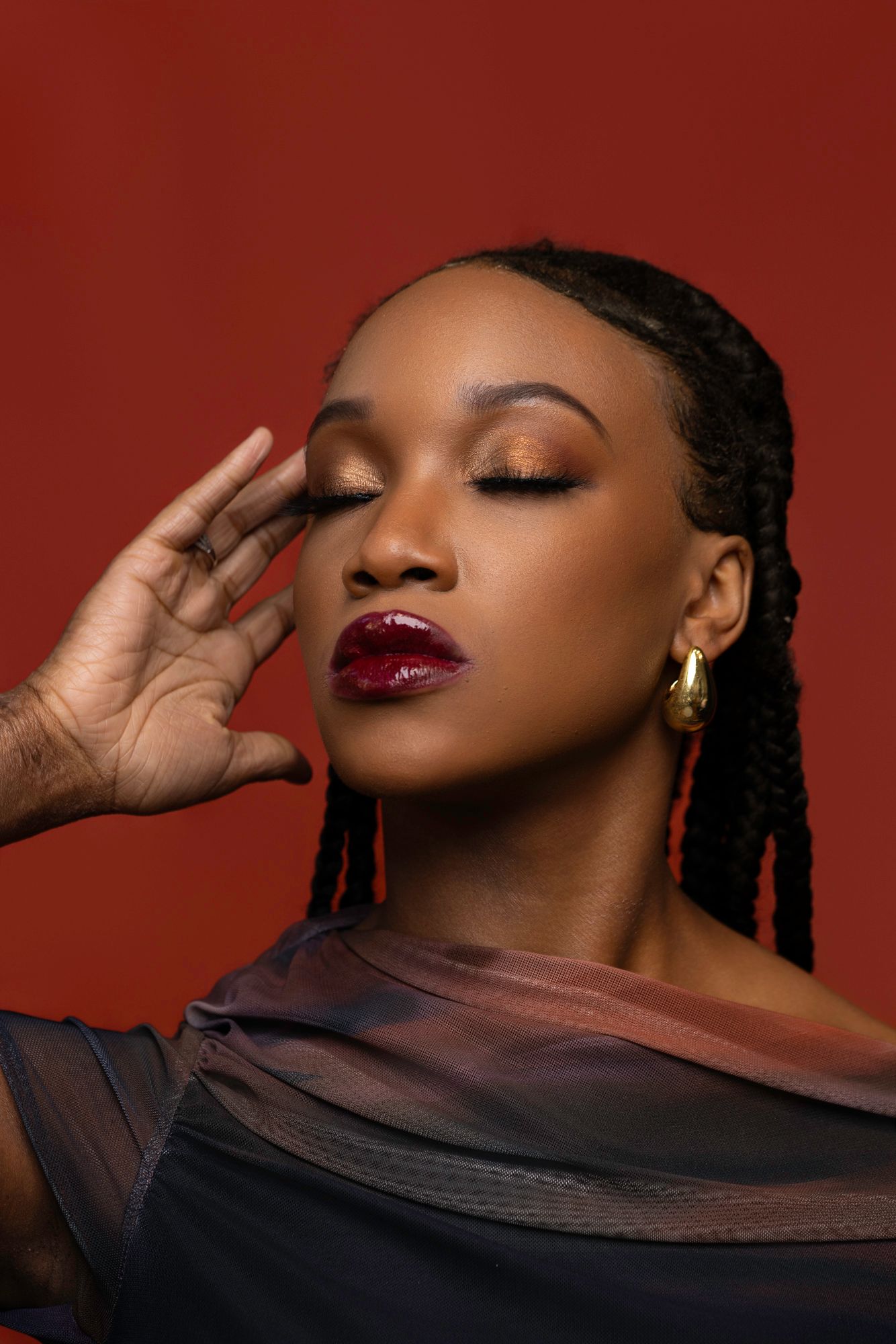 Artistic fashion portrait series with dramatic poses and flowing fabric against red backdrop.