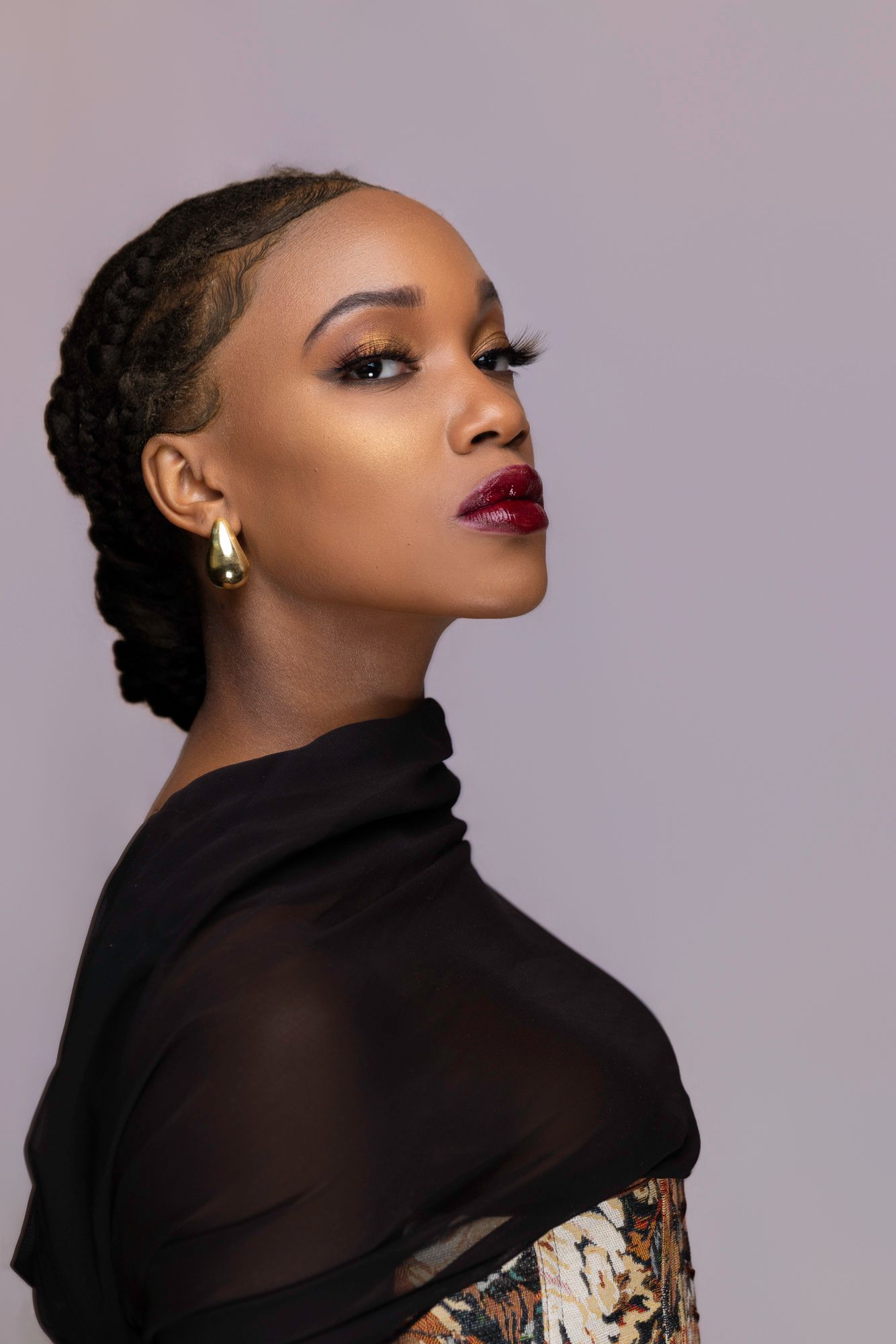 Elegant studio portrait featuring black sheer turtleneck and glamorous makeup.