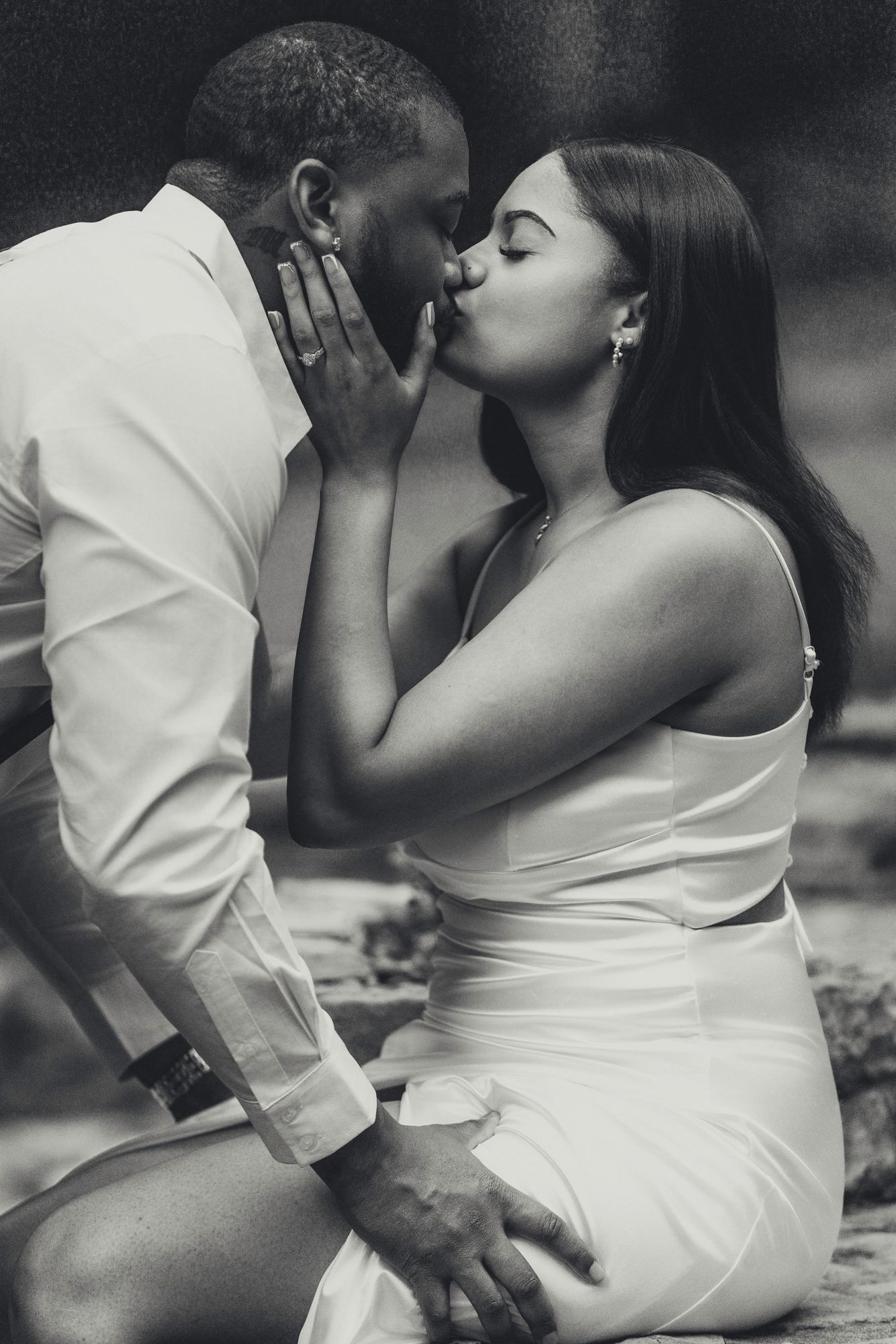 An intimate black and white portrait of a couple sharing a tender moment.