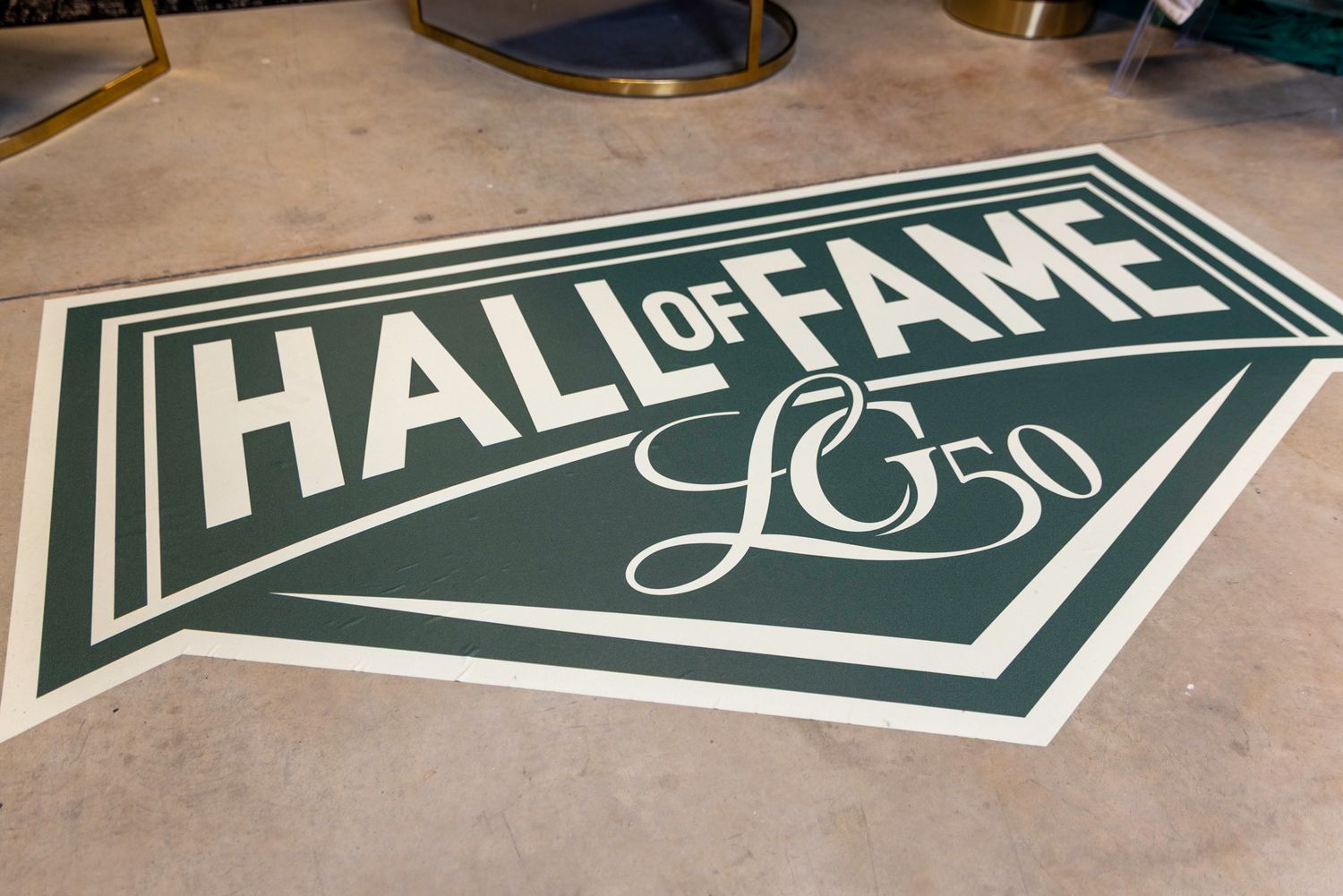 Floor decal showing 'Hall of Fame' text in dark green and white design.
