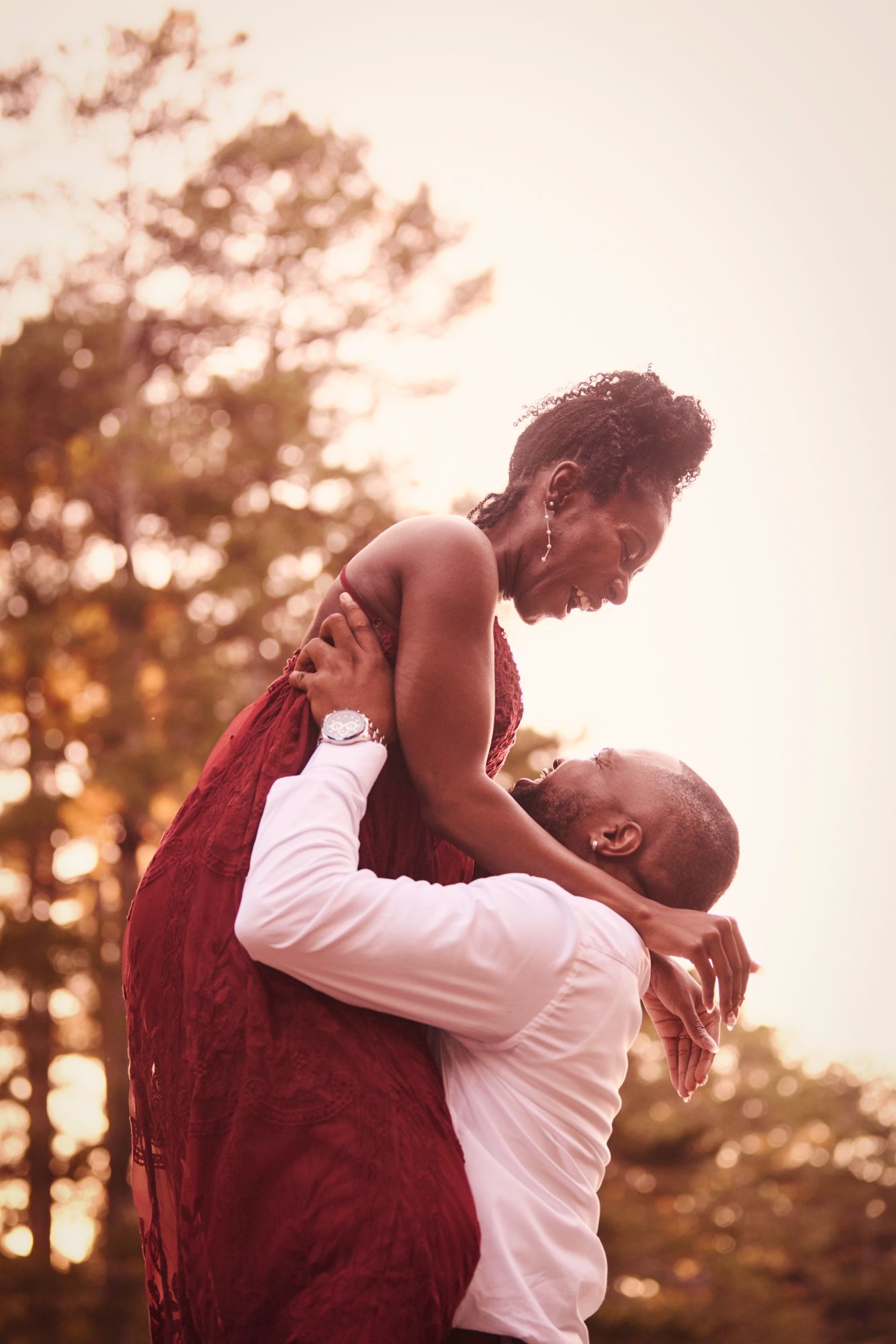 A romantic moment captured at sunset with a couple in an intimate lift pose.