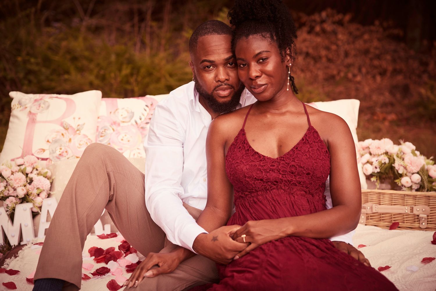 Romantic proposal scene with couple embracing on a decorated outdoor deck.