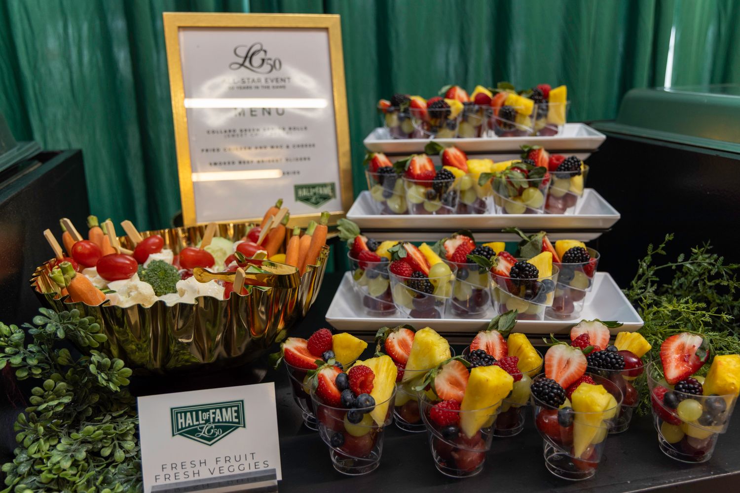 Colorful fruit and vegetable appetizer cups arranged on a catering display.