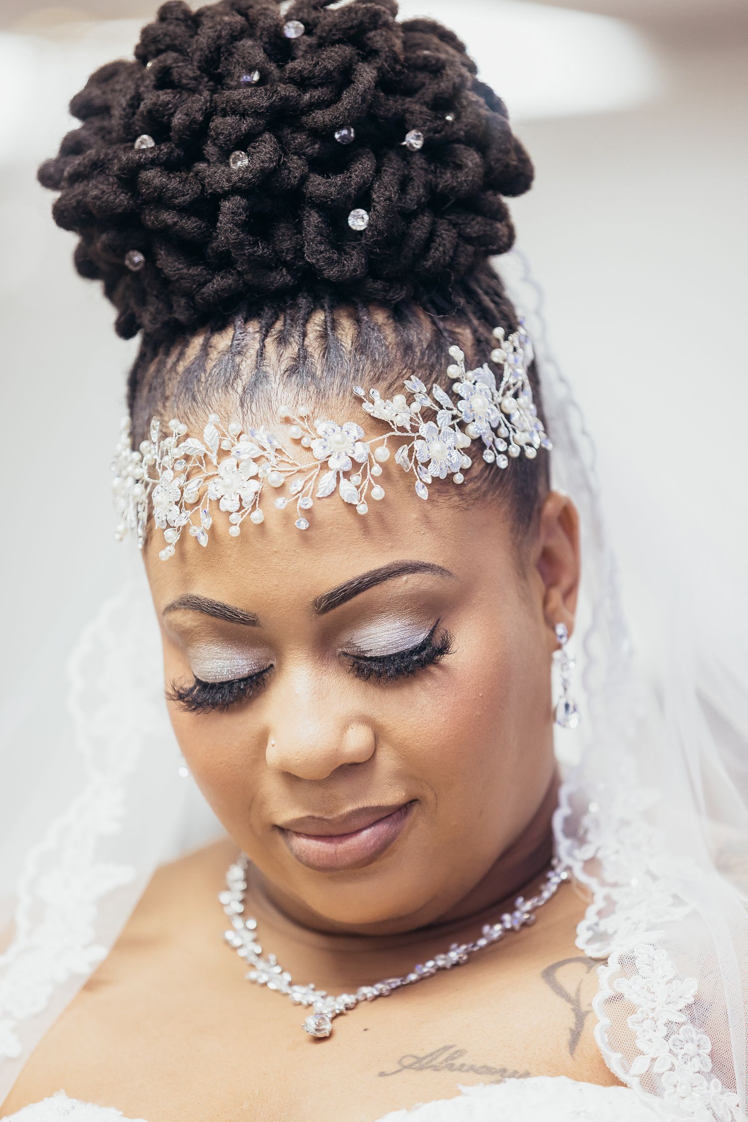 Bridal portrait featuring crystal headpiece, veil and elegant updo hairstyle.