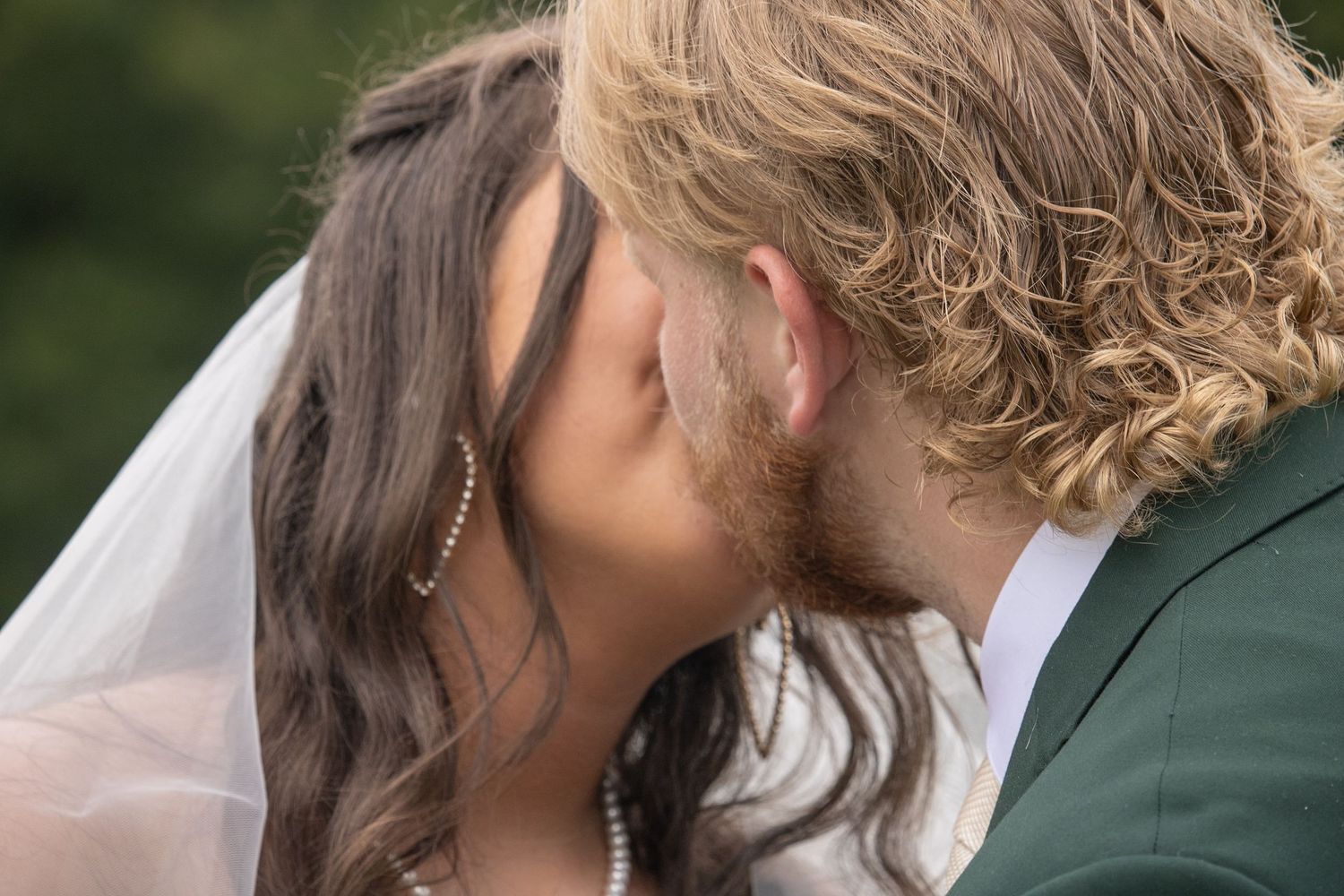 Close-up of bride and groom sharing a tender kiss on their wedding day.