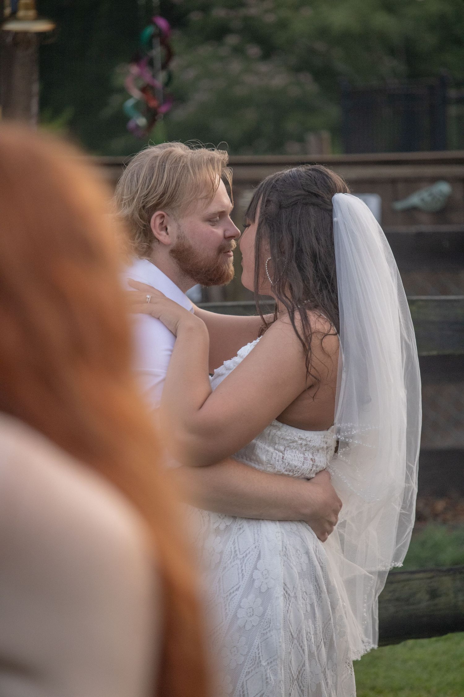 Bride and groom share intimate forehead touch moment during outdoor wedding ceremony at dusk.