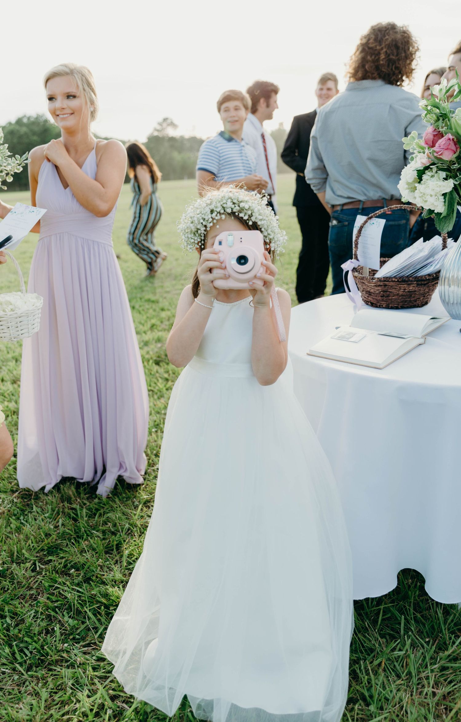Flower girl playing with polaroid.
