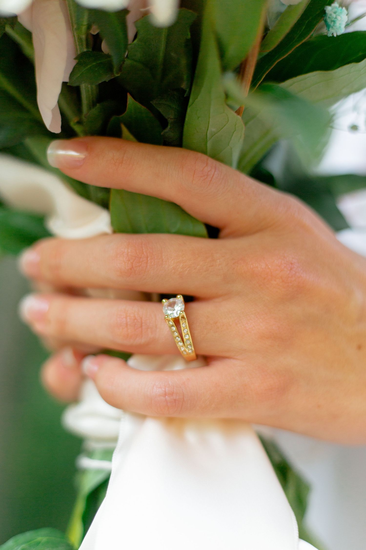 Closeup of engagement ring and bridal bouquet.