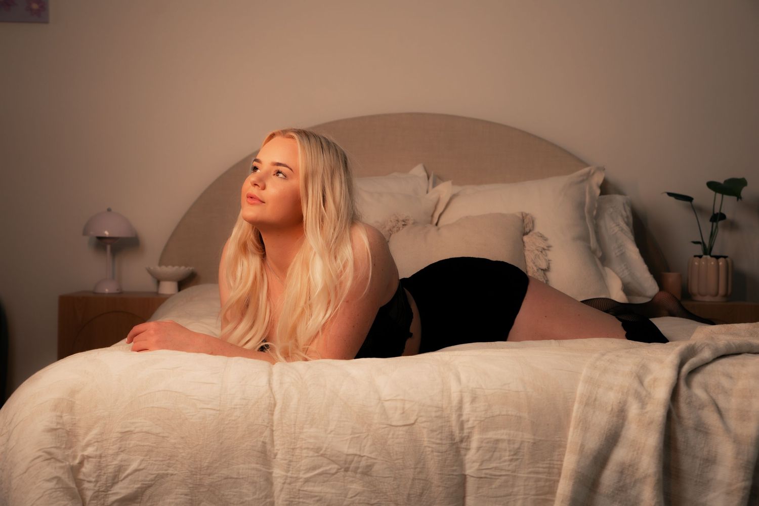 woman laying on bed in thoughtful pose