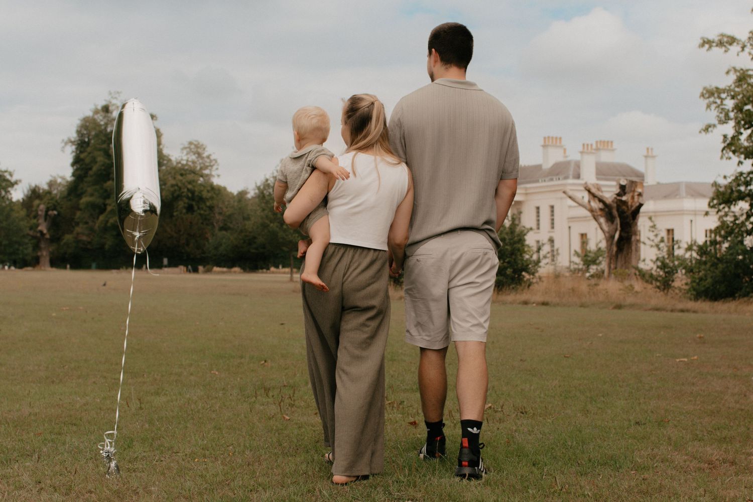 Couple walks hand in hand across an expansive green field at sunset with varied photo angles showing their journey.